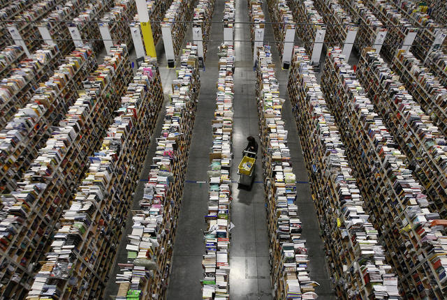 Inside the Amazon warehouse. A worker gathers items for delivery.